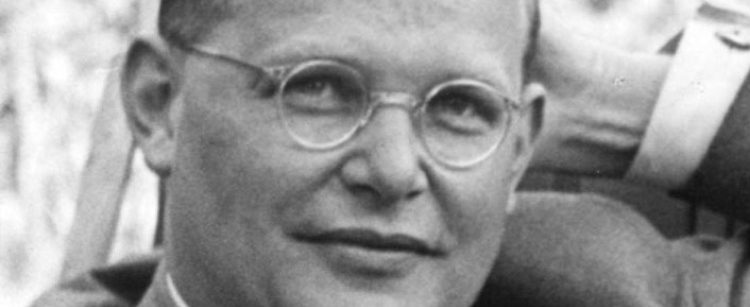 Ein Schwarzweißfoto von Dietrich Bonhoeffer mit runder Brille, kurzen Haaren und entspanntem Gesichtsausdruck.